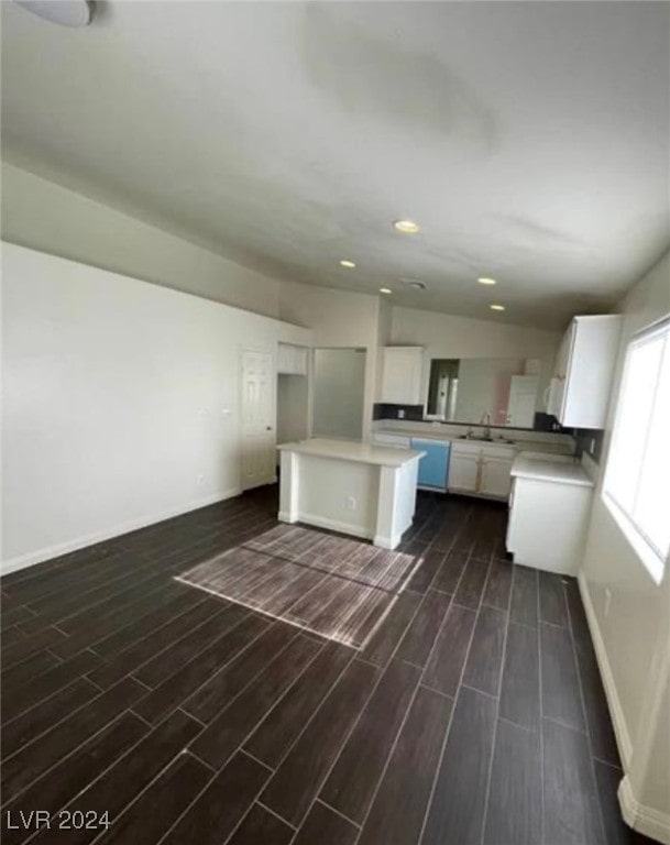 kitchen with a kitchen island, white cabinets, dark hardwood / wood-style flooring, and sink