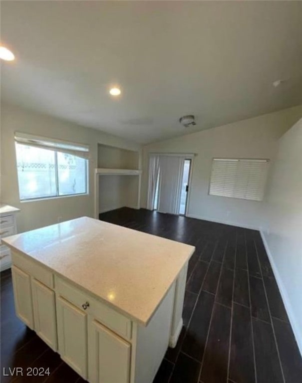 kitchen with dark hardwood / wood-style flooring, lofted ceiling, and a kitchen island