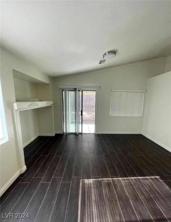 unfurnished living room with dark hardwood / wood-style floors and lofted ceiling