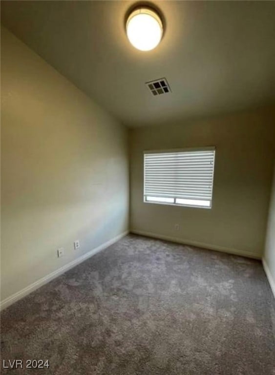 empty room with vaulted ceiling and carpet floors