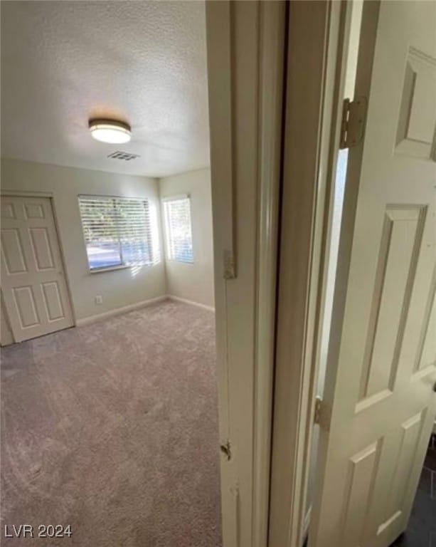 spare room featuring carpet floors and a textured ceiling