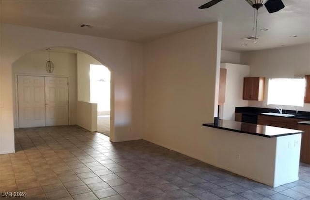 kitchen featuring light tile patterned floors, sink, and ceiling fan