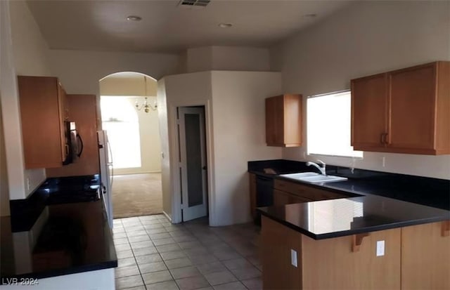 kitchen featuring sink, kitchen peninsula, light colored carpet, and a healthy amount of sunlight