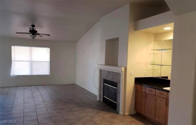 unfurnished living room featuring ceiling fan, light tile patterned floors, and a fireplace