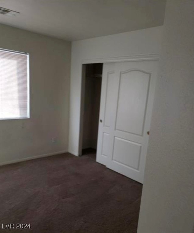 unfurnished bedroom featuring carpet floors and a closet