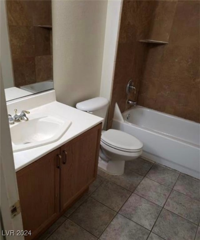 full bathroom with tile patterned floors, tiled shower / bath, vanity, and toilet