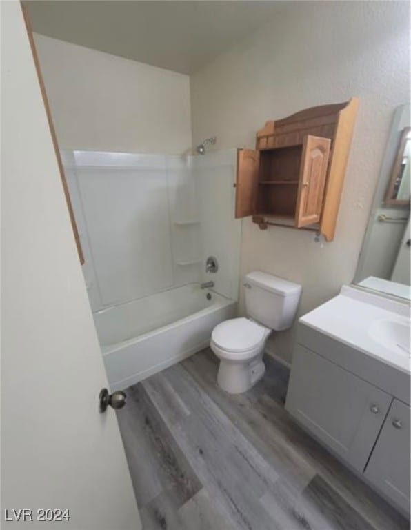 full bathroom featuring toilet, hardwood / wood-style flooring, shower / washtub combination, and vanity