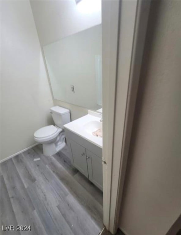 bathroom featuring vanity, hardwood / wood-style floors, and toilet