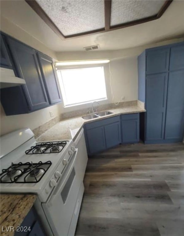 kitchen with dark hardwood / wood-style floors, sink, extractor fan, white gas range, and blue cabinets