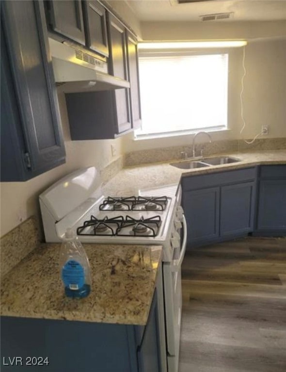 kitchen featuring sink, dark hardwood / wood-style floors, wall chimney exhaust hood, and a wealth of natural light