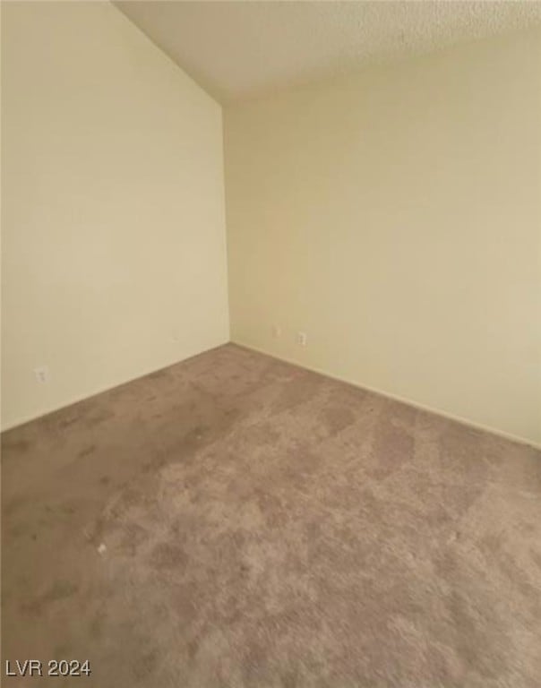 carpeted empty room with a textured ceiling