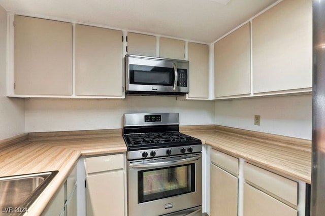 kitchen with sink, appliances with stainless steel finishes, and cream cabinetry