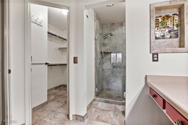 bathroom featuring a shower with door and a textured ceiling