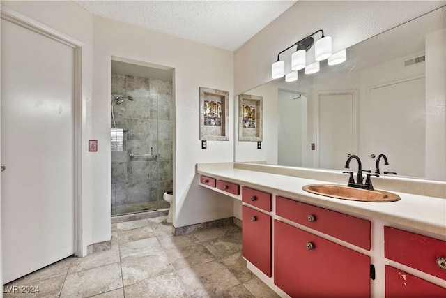 bathroom featuring vanity, a textured ceiling, and a shower with door