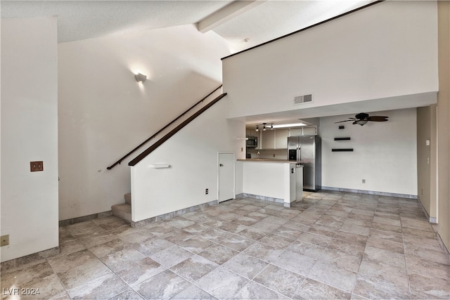 unfurnished living room with high vaulted ceiling and beam ceiling