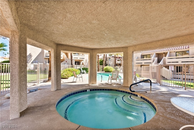 view of pool featuring a community hot tub and a patio