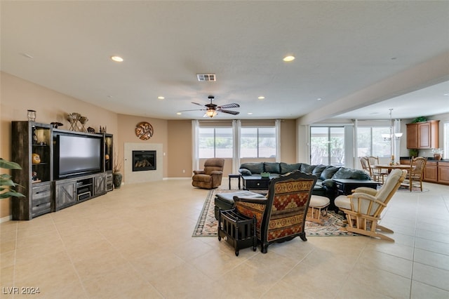 living room with ceiling fan, a wealth of natural light, and light tile patterned floors