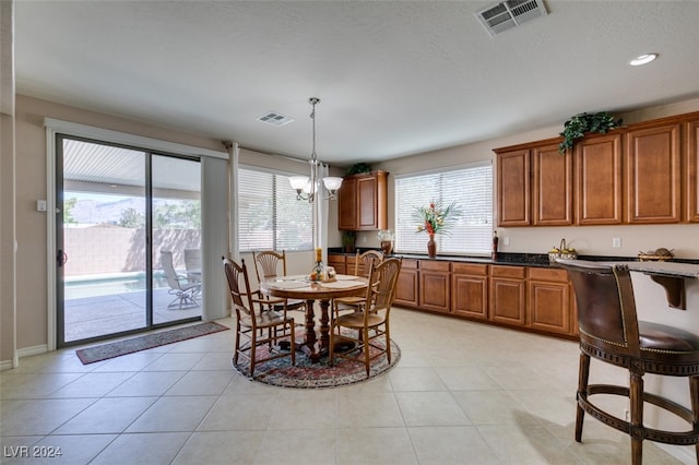 dining space with light tile patterned flooring and an inviting chandelier