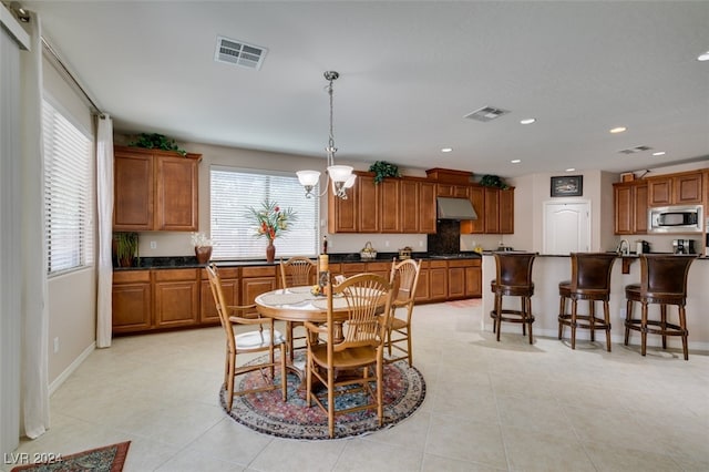 tiled dining space with plenty of natural light and a chandelier