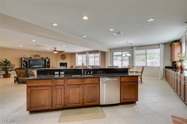 kitchen with sink, light tile patterned flooring, ceiling fan with notable chandelier, and stainless steel dishwasher