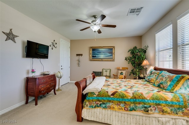 bedroom featuring ceiling fan, multiple windows, and light carpet