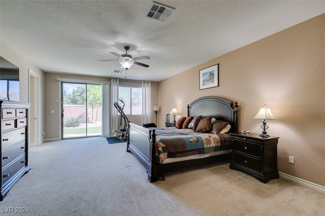 carpeted bedroom with ceiling fan, access to outside, and a textured ceiling