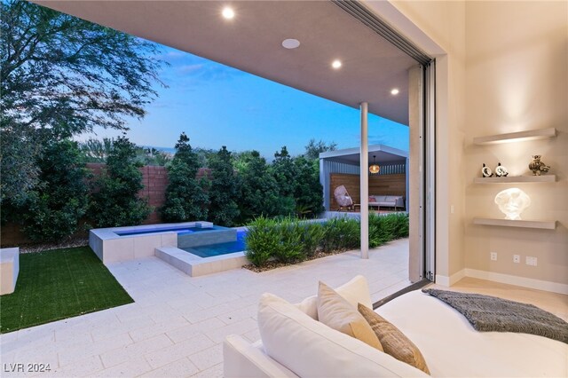 patio terrace at dusk featuring an in ground hot tub