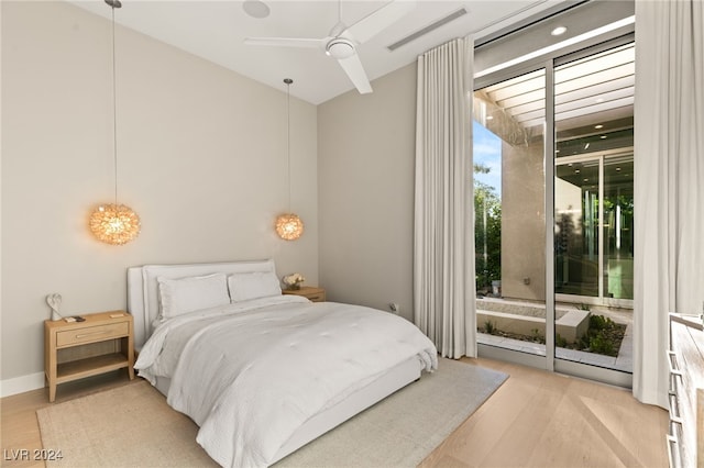 bedroom with ceiling fan, access to outside, light hardwood / wood-style floors, and floor to ceiling windows