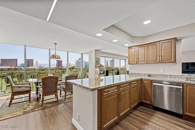 kitchen featuring light stone counters, kitchen peninsula, stainless steel dishwasher, dark hardwood / wood-style floors, and pendant lighting