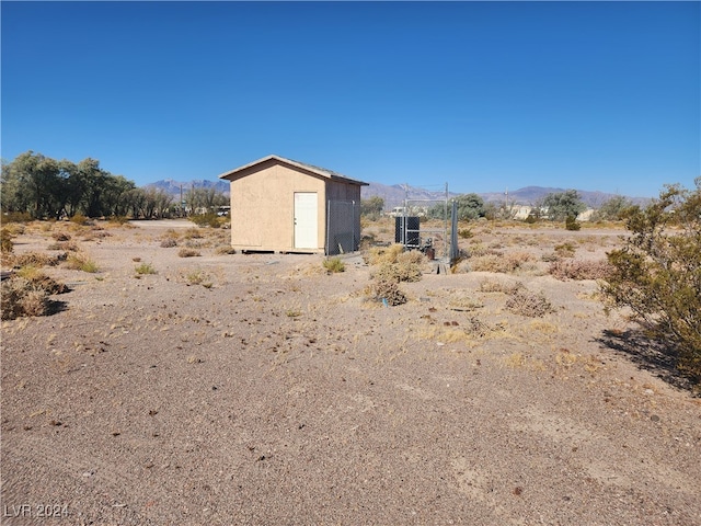 exterior space with a storage unit, a rural view, and a mountain view