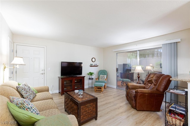 living area with light wood-style flooring and baseboards