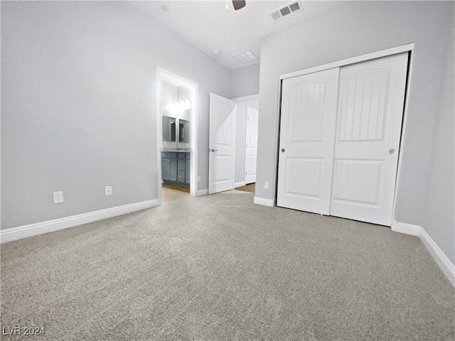 unfurnished bedroom featuring a closet, ceiling fan, and ensuite bath