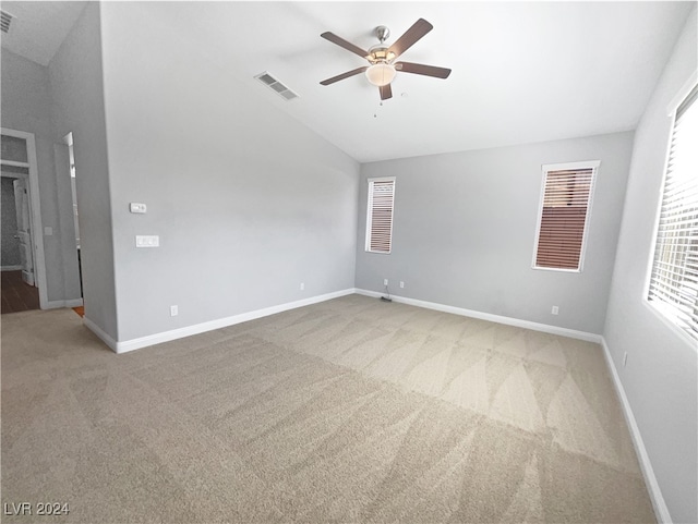 spare room featuring carpet flooring, ceiling fan, and vaulted ceiling