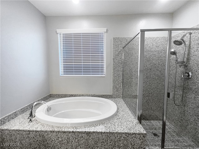 bathroom featuring independent shower and bath