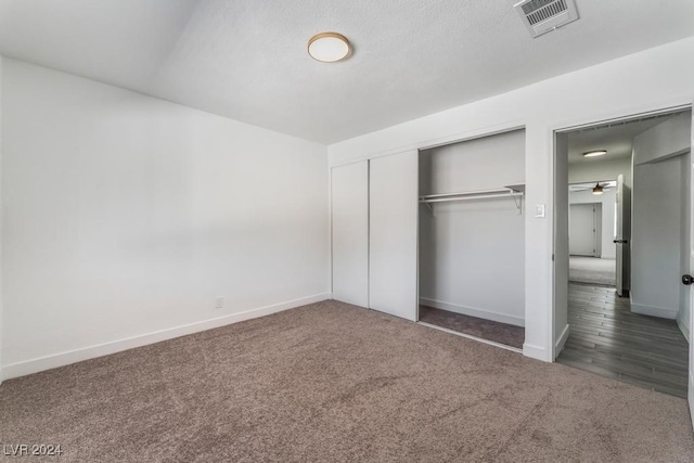 unfurnished bedroom with a closet and dark hardwood / wood-style flooring