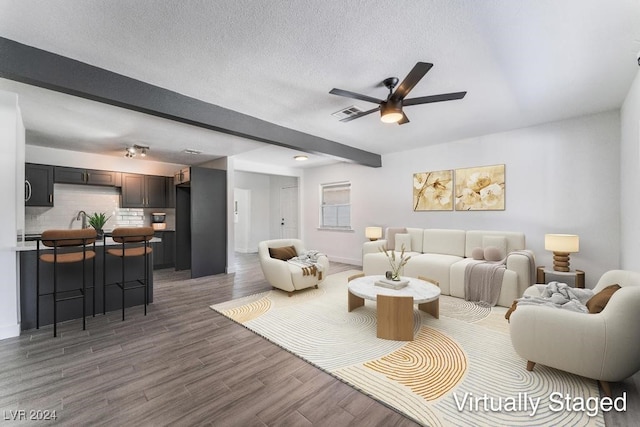 living room with ceiling fan, dark hardwood / wood-style floors, and a textured ceiling