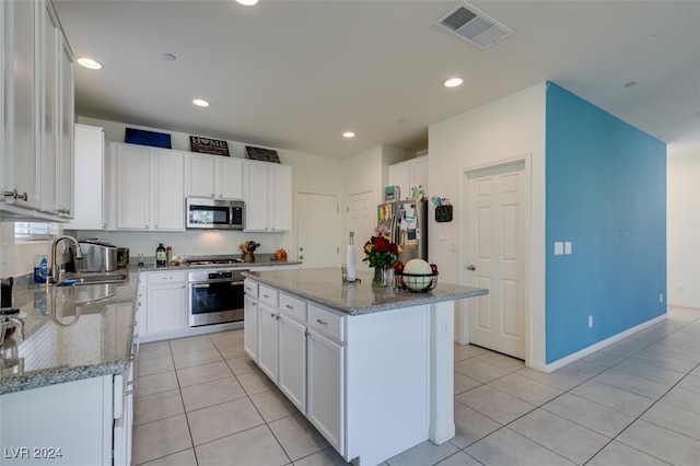 kitchen with white cabinetry, visible vents, stainless steel appliances, and a center island