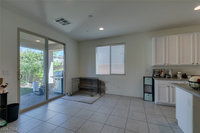 kitchen featuring visible vents, a wealth of natural light, light tile patterned flooring, and white cabinetry