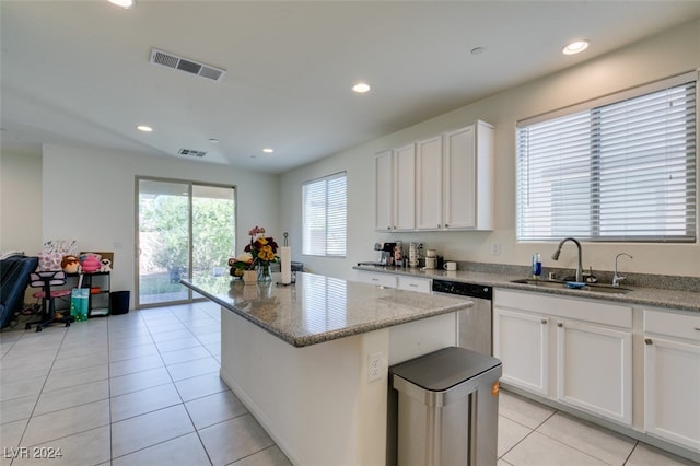 kitchen featuring a kitchen island, a sink, visible vents, white cabinets, and stainless steel dishwasher