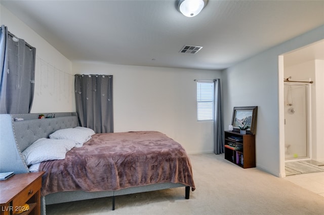 bedroom with visible vents, connected bathroom, and light colored carpet