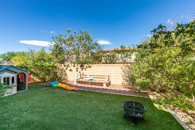 view of yard with a fire pit, a garden, and fence