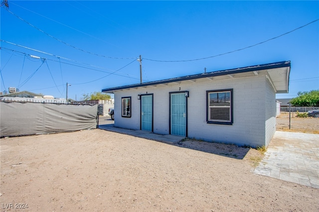 rear view of property featuring brick siding and fence