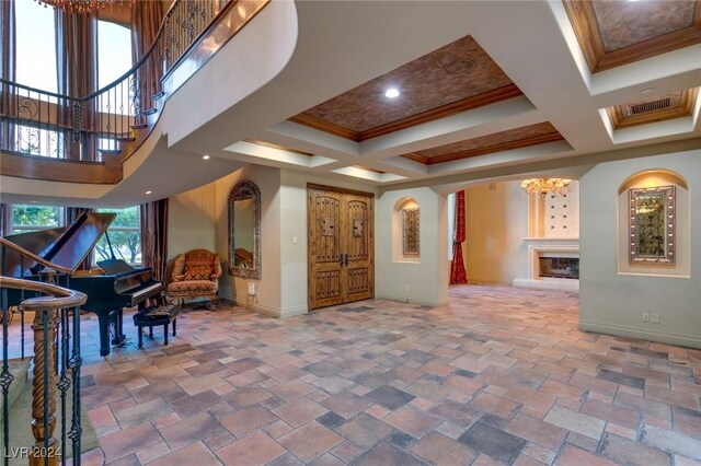 interior space with a high ceiling, crown molding, beamed ceiling, and coffered ceiling