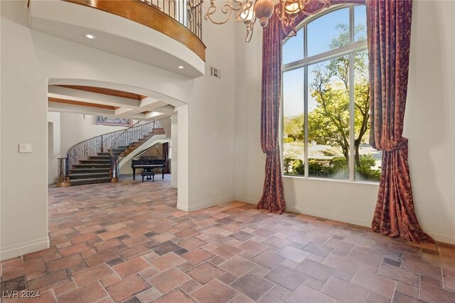 interior space with a towering ceiling and an inviting chandelier