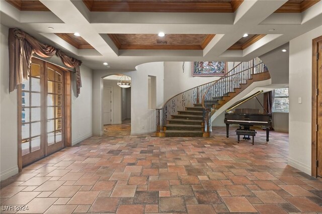 foyer entrance featuring tile patterned floors, french doors, and coffered ceiling