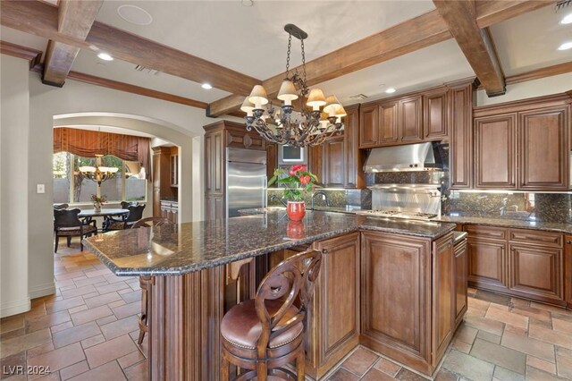 kitchen featuring light tile patterned flooring, stainless steel built in refrigerator, tasteful backsplash, and a kitchen island