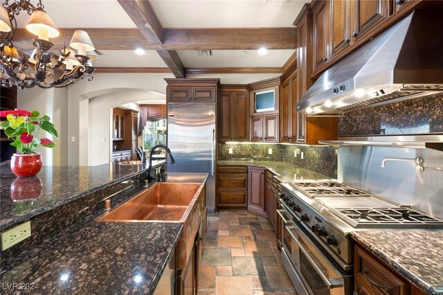 kitchen featuring backsplash, dark tile patterned floors, an inviting chandelier, beamed ceiling, and high end appliances