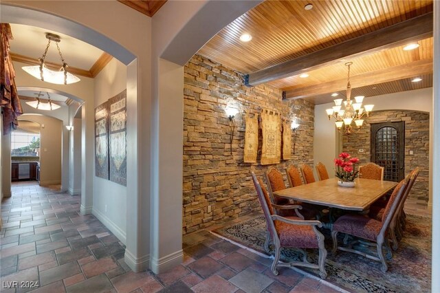 dining space featuring beam ceiling, dark tile patterned floors, a chandelier, and wood ceiling