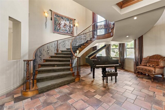 staircase with tile patterned flooring and a high ceiling