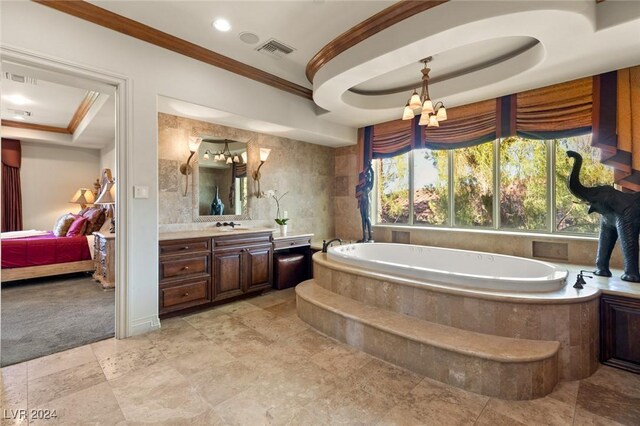 bathroom featuring tiled bath, tile patterned flooring, a raised ceiling, and vanity